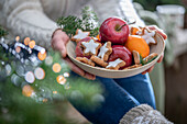 Weihnachtlicher Teller mit Zimtsternen, Äpfeln und Mandarinen