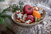 Weihnachtlicher Teller mit Zimtsternen, Äpfeln und Mandarinen