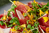 Smoked beef carpaccio with wild herbs, flowers and parmesan crisps