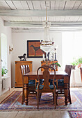 Dining room with wooden furniture, chandelier and dog painting