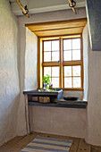 Rustic kitchen niche with small window, sink and herb pot