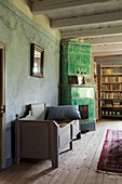 Historic living room with green tiled stove and wooden beamed ceiling