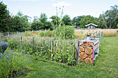 Flower bed and insect hotel in a country garden in summer