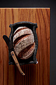 Rustic bread in bread slicer with knife