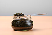 Glass jar with black caviar and spoon