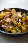 Baked potato wedges with herbs in a pan