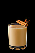 Hot drink with milk, cinnamon stick and star anise