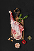 Leg of lamb with rosemary and spices on a wooden board