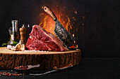 Raw porterhouse steak on wooden board with butcher's cleaver