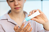 Woman using medical ointment from tube