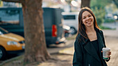 Smiling teenage girl holding cup of coffee