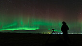 Photographer observing northern lights, Iceland