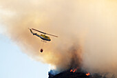 Helicopter dropping water on wildfire