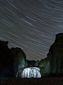 Stars over a waterfall, Iceland, long-exposure