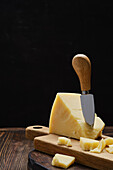 Piece of parmesan on cutting board with cheese knife