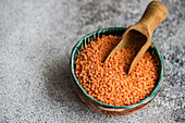 Red lentils in bowl with wooden spoon