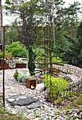 Rock garden with modern metal accents and evergreen plants in summer