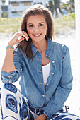 Young woman wearing a denim jacket, a white shirt and blue and white patterned trousers