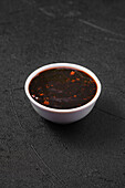 Small bowl with spicy teriyaki sauce.