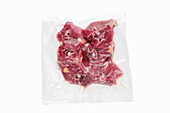 Vacuum-packed lamb neck on a white background