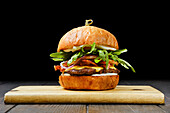 Beef burger with cheese, bacon and rocket salad