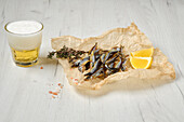 Smoked smelts with lemon wedges and spices