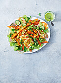 Salad with sweet potato wedges, halloumi and green dressing