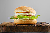 Chicken burger with fried egg and iceberg lettuce