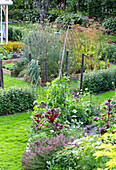 Üppiger Garten mit Gemüse- und Blumenbeeten im Sommer