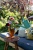 Bouquet of summer flowers in a vase on a stool in the garden