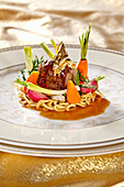 Lamb shoulder cooked on hay with spring vegetables and pasta