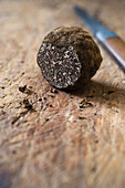 Sliced black truffle on a wooden board