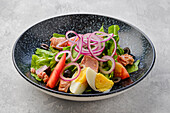 Salad with salmon, egg, tomato and red onion