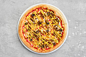 Overhead view of small size pizza with minced beef meat, sweet corn and mustard sauce