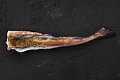 Frozen raw pollock carcass on wooden background