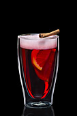 Double-walled glass with hot mulled wine isolated on black