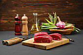 Ribeye steaks on a cutting board with herbs