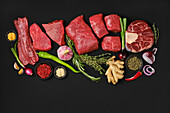 Various raw pieces of beef with spices and herbs
