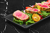 Sesame-crusted tuna on a bed of lettuce