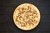 Pizza with bacon, ham, champignon and fried onion, top view