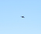 Kleine Drohne in der Luft vor blauem Himmel aus geringer Höhe
