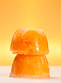 Two cups of frozen mandarins on orange background
