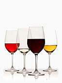 Glasses of red, white and rose wine on white background