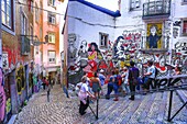 Portugal, Lissabon, Gruppe von Touristen bewundert ein Fresko mit Straßenkunst in der Gasse Sao Cristovao