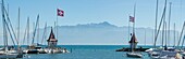 Switzerland, Canton of Vaud, Morges, panoramic view of the guardian turrets of the port and the Chablais massif