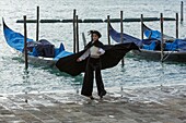Italy, Veneto, Venice listed as World Heritage by UNESCO, San Marco district, Saint Mark's Square (Piazza San Marco), tourist dressed with a carnival costume and gondolas at Riva degli Schiavoni wharf