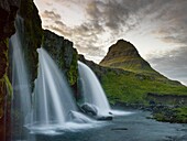 Island, Westliche Region, Grundafjordur, Kirkjufell und Kirkjufellsfoss Wasserfälle bei Sonnenuntergang