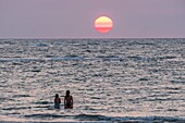 Frankreich, Charente Maritime, Insel Oleron, junge Frauen am Strand bei Sonnenuntergang