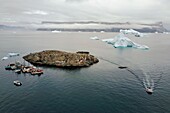 Greenland, west coast, Uummannaq fjord, boats for fishing and hunting, icebergs at the exit of the port (aerial view)