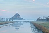France, Manche, the Mont-Saint-Michel, view of the island and the abbey at sunrise from the mouth of the Couesnon river